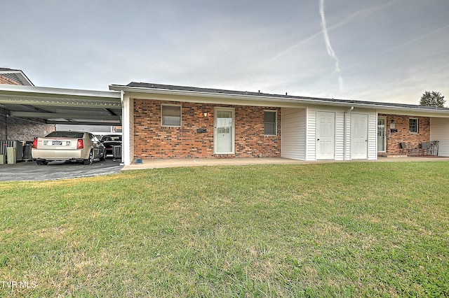 ranch-style house featuring a front lawn and a carport