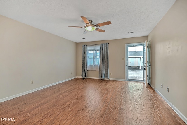 empty room with hardwood / wood-style floors, ceiling fan, and a textured ceiling