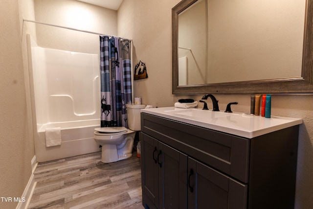 full bathroom featuring shower / bath combo with shower curtain, vanity, hardwood / wood-style floors, and toilet