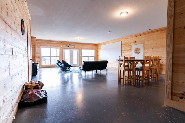 dining room with french doors and wood walls