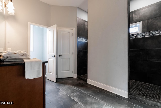 bathroom with tile patterned flooring and a tile shower