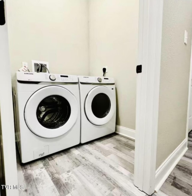 clothes washing area featuring light hardwood / wood-style floors and washing machine and clothes dryer