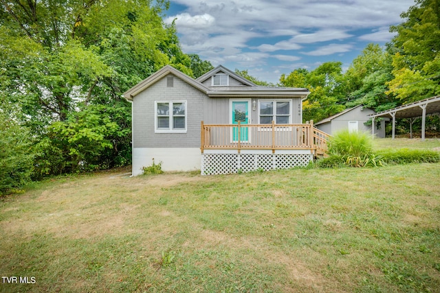 back of house with a wooden deck, a yard, and a carport