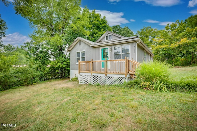 back of property with a lawn and a wooden deck