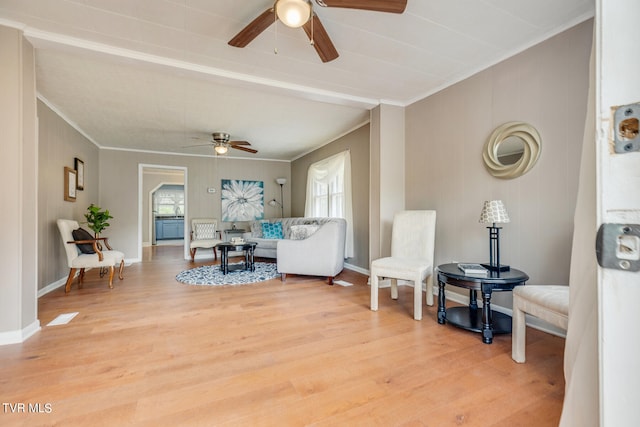 living room with ceiling fan, wood-type flooring, crown molding, and plenty of natural light