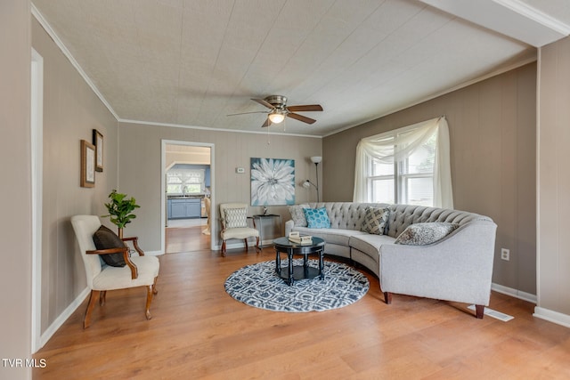 living room with hardwood / wood-style flooring, crown molding, and ceiling fan