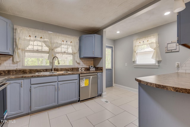 kitchen featuring stainless steel appliances, a wealth of natural light, sink, and backsplash