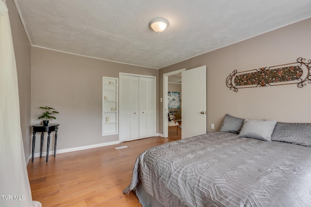 bedroom featuring hardwood / wood-style floors, a textured ceiling, and a closet