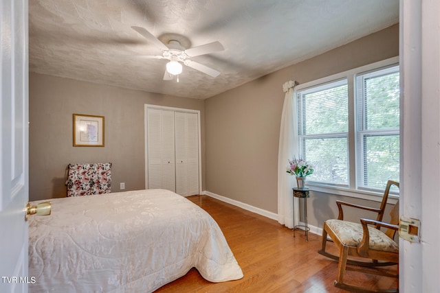 bedroom featuring hardwood / wood-style flooring, ceiling fan, a textured ceiling, and a closet