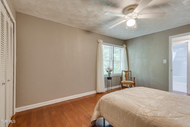 bedroom featuring a closet, wood-type flooring, ceiling fan, and a textured ceiling