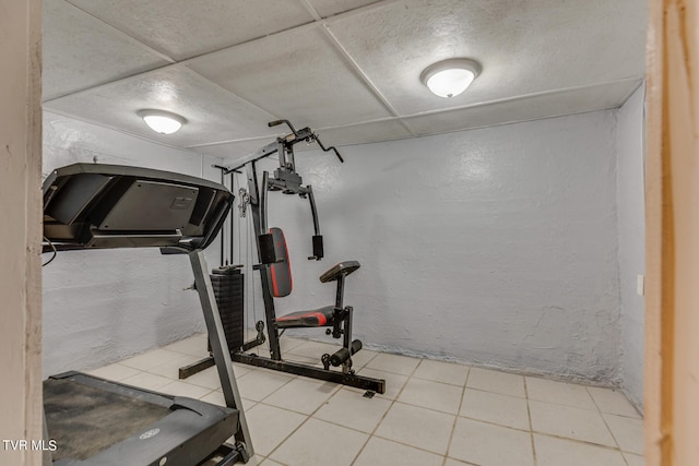 exercise room featuring tile patterned floors and a drop ceiling