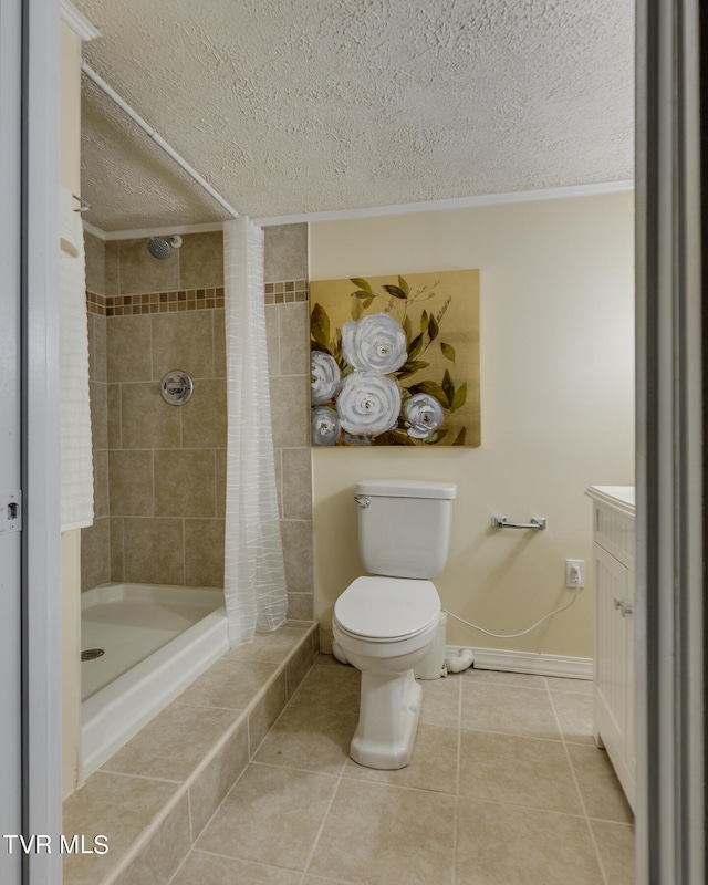 bathroom with toilet, vanity, a textured ceiling, and tile patterned floors