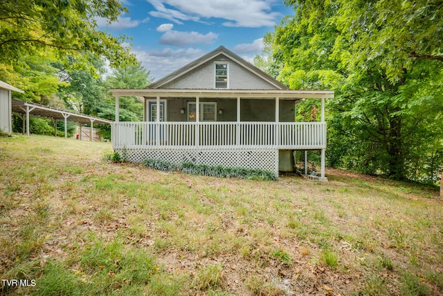 rear view of house with a sunroom and a yard