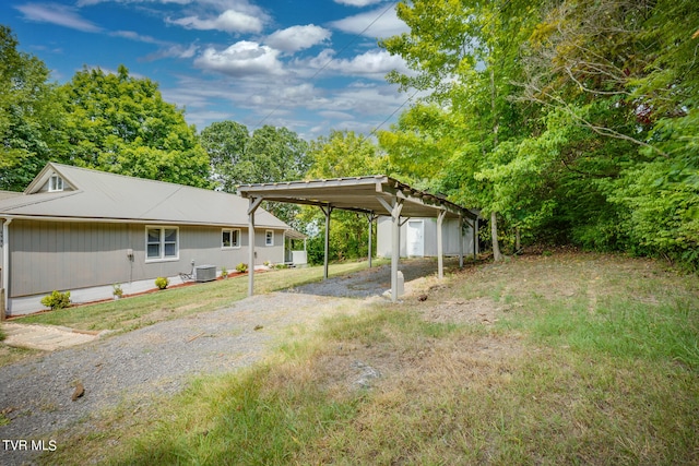 view of yard with central AC unit and a carport