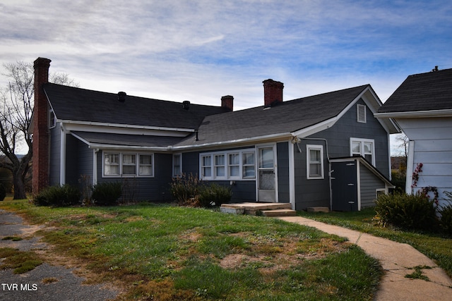 rear view of property featuring a yard