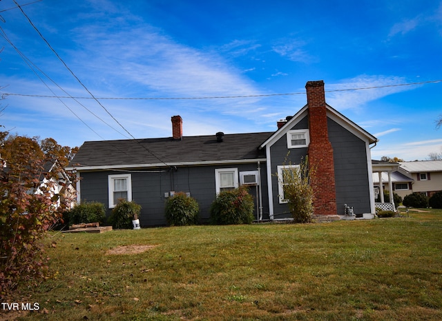 rear view of property with a yard