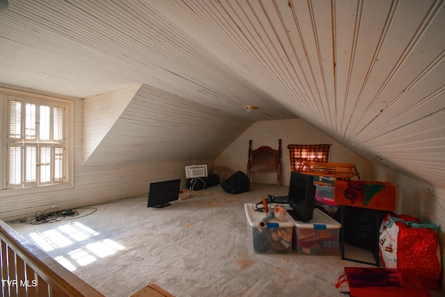 bonus room with an AC wall unit, lofted ceiling, and carpet floors