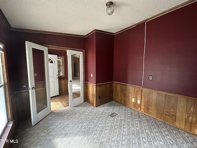 11511 Meade Fork Rd, Pound, VA 24279 - carpeted spare room featuring french doors, a textured ceiling, a wainscoted wall, and wood walls