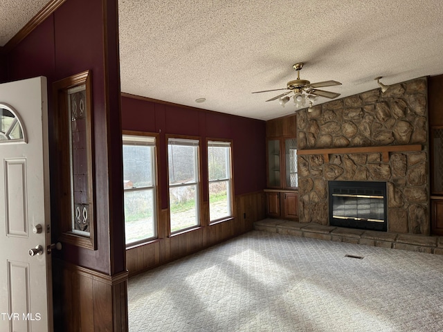 unfurnished living room featuring ceiling fan, a textured ceiling, carpet, a fireplace, and lofted ceiling