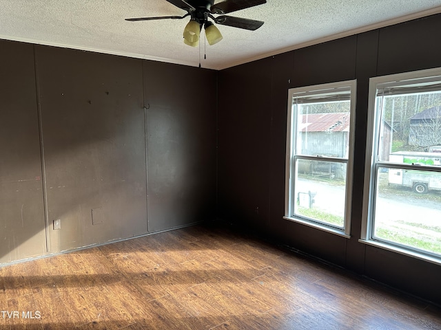 11511 Meade Fork Rd, Pound, VA 24279 - spare room featuring wood finished floors, a textured ceiling, a ceiling fan, plenty of natural light, and a decorative wall