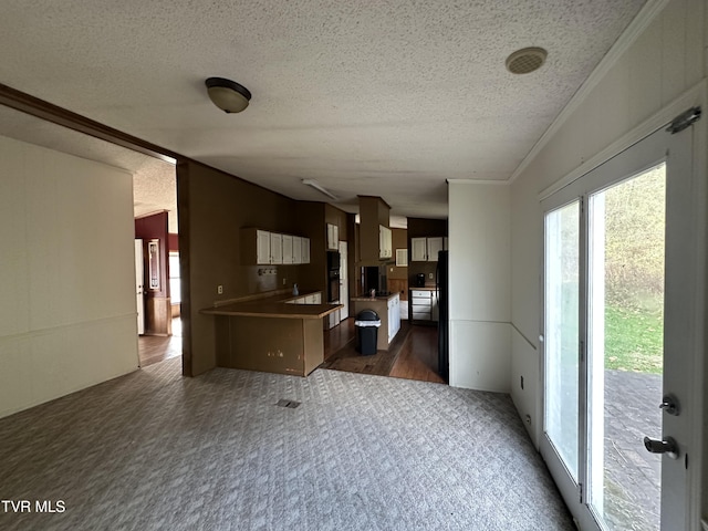 11511 Meade Fork Rd, Pound, VA 24279 - kitchen with a textured ceiling, dark carpet, a peninsula, open floor plan, and ornamental molding