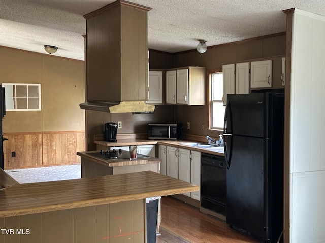 11511 Meade Fork Rd, Pound, VA 24279 - kitchen with black appliances, a textured ceiling, wood finished floors, wooden walls, and white cabinetry