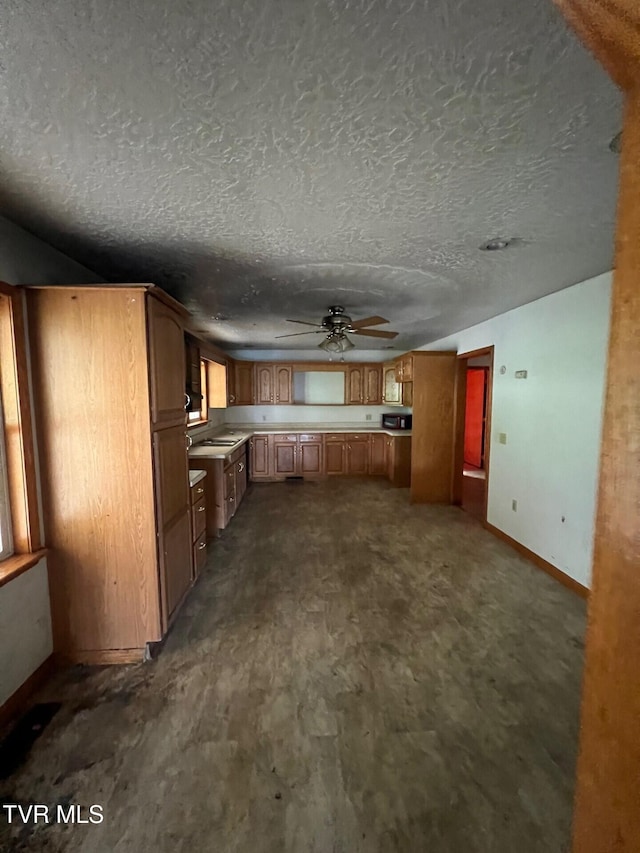 kitchen featuring ceiling fan and a textured ceiling