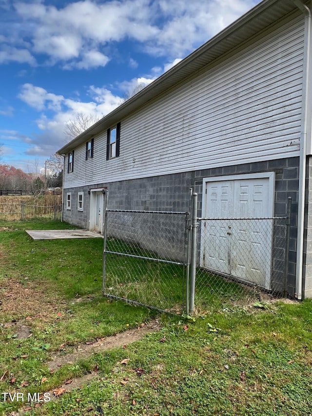 rear view of house featuring a lawn and a storage unit