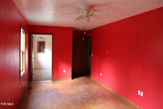 unfurnished bedroom featuring light hardwood / wood-style floors, ceiling fan, and a textured ceiling