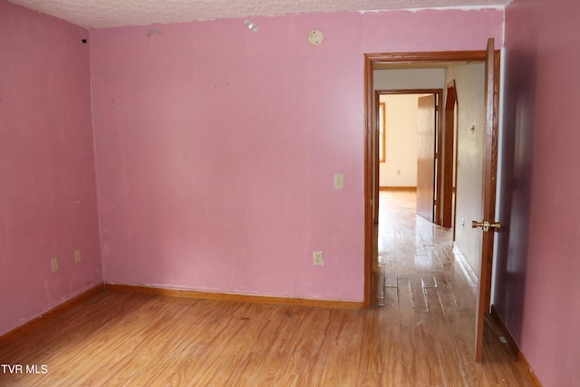 empty room featuring light hardwood / wood-style floors and a textured ceiling