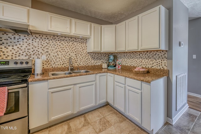 kitchen featuring under cabinet range hood, electric range, a sink, visible vents, and white cabinets