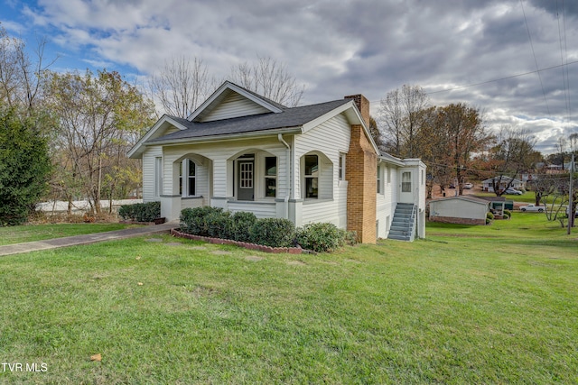 view of side of property with a yard and covered porch