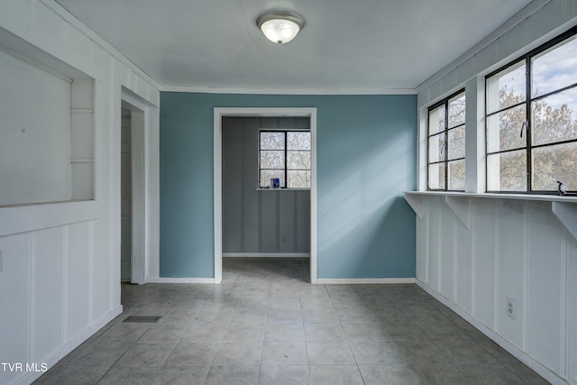 empty room featuring a wealth of natural light and crown molding