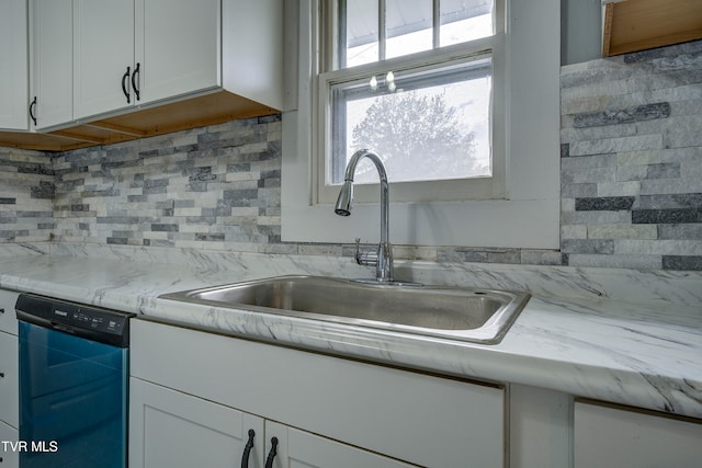 kitchen featuring backsplash, white cabinetry, sink, and black dishwasher