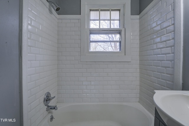 bathroom featuring vanity and tiled shower / bath