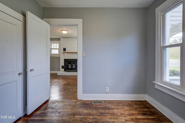 empty room featuring dark wood-type flooring and a wealth of natural light