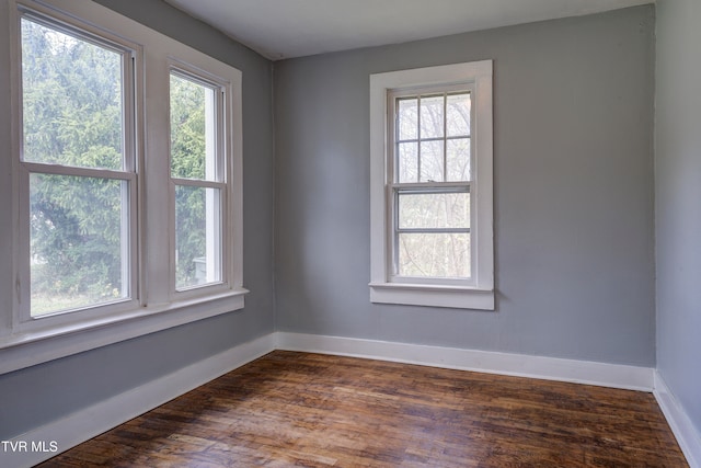 unfurnished room with dark hardwood / wood-style flooring and a wealth of natural light