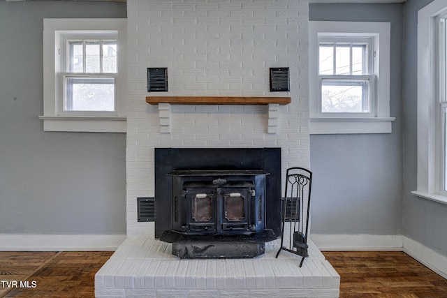 interior details with a wood stove and hardwood / wood-style flooring