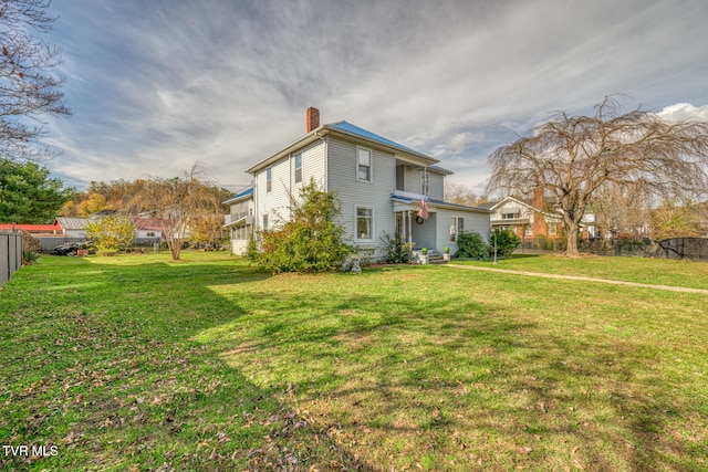 rear view of house featuring a yard