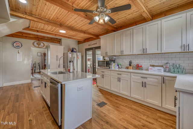 kitchen with white cabinetry, appliances with stainless steel finishes, sink, an island with sink, and light hardwood / wood-style floors