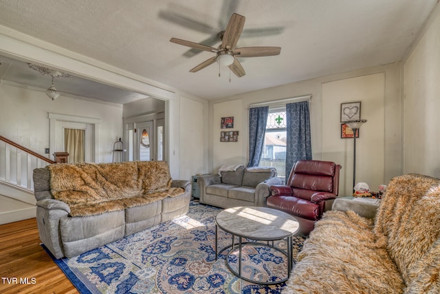 living room with a textured ceiling, hardwood / wood-style flooring, and ceiling fan