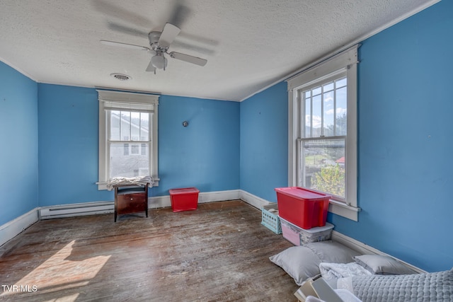 misc room featuring hardwood / wood-style flooring, a baseboard radiator, a textured ceiling, and ceiling fan