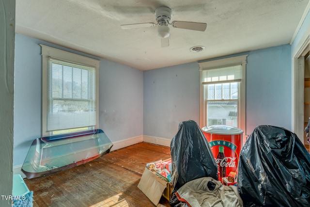 interior space featuring hardwood / wood-style floors, ceiling fan, and a textured ceiling