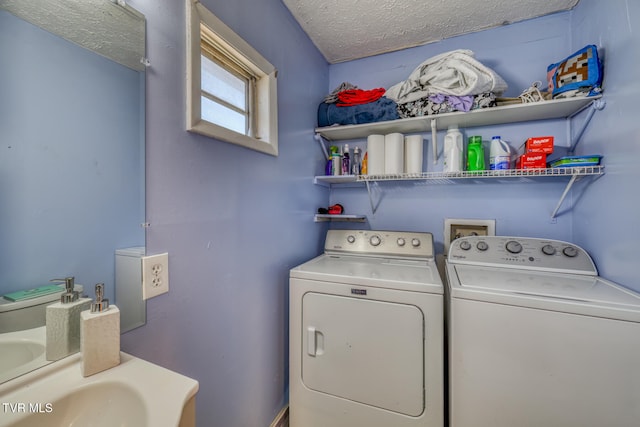 laundry area with a textured ceiling and separate washer and dryer