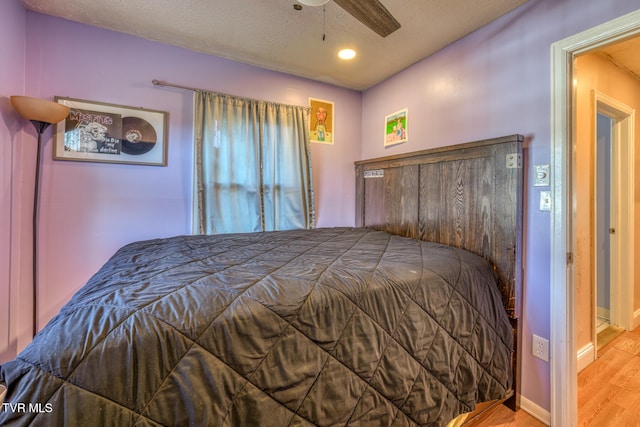 bedroom with ceiling fan, a textured ceiling, and light wood-type flooring