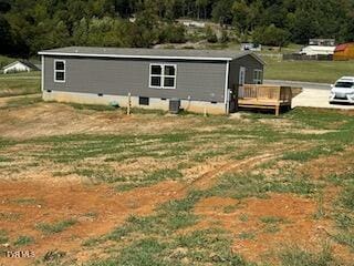 rear view of house featuring a yard and a deck