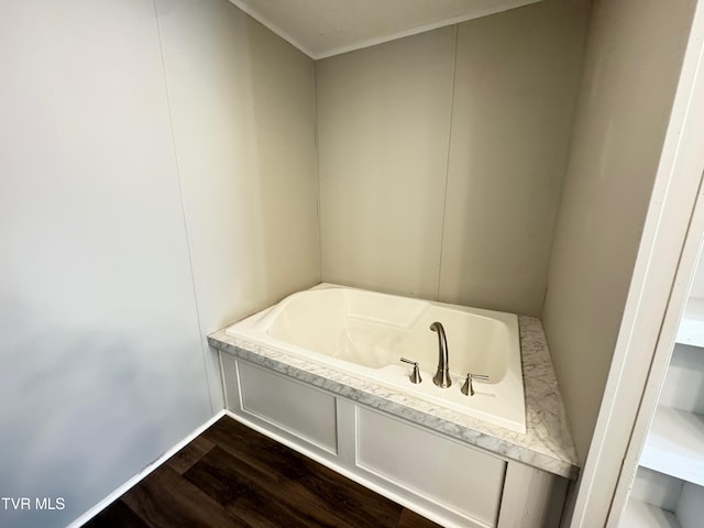 bathroom featuring wood-type flooring, a bathtub, and crown molding