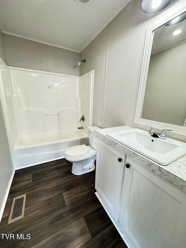 full bathroom featuring hardwood / wood-style floors, shower / washtub combination, toilet, and vanity