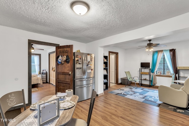 dining room with a textured ceiling, hardwood / wood-style flooring, and ceiling fan