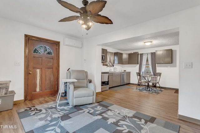 552 Jerrys Br, Clintwood, VA 24228 - living area with a wall mounted AC, light wood finished floors, baseboards, and ceiling fan